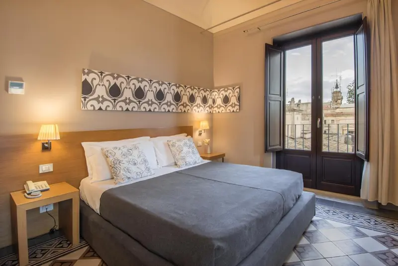Une chambre à coucher avec un grand lit et une fenêtre donnant sur la ville.