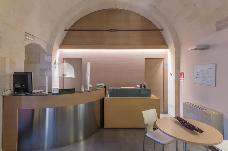 Un comptoir d'accueil incurvé en métal et bois clair dans un espace lumineux.