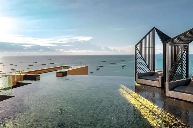 Une piscine à débordement offre une vue sur la mer et les bateaux.