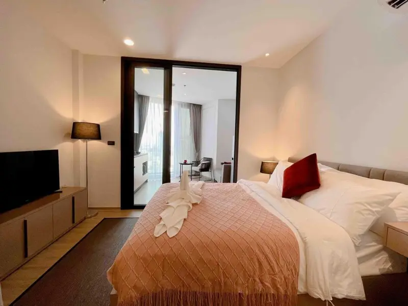 Une chambre lumineuse avec un grand lit et un accès à une terrasse.