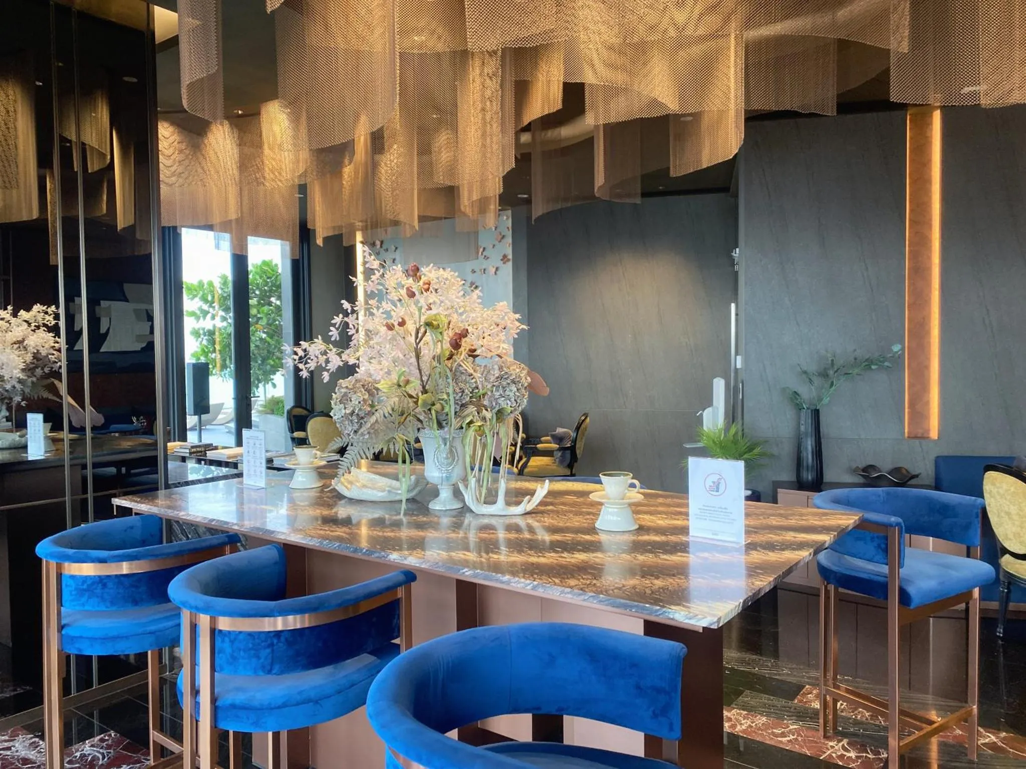Une table en marbre est mise en scène avec des fleurs et des couverts.