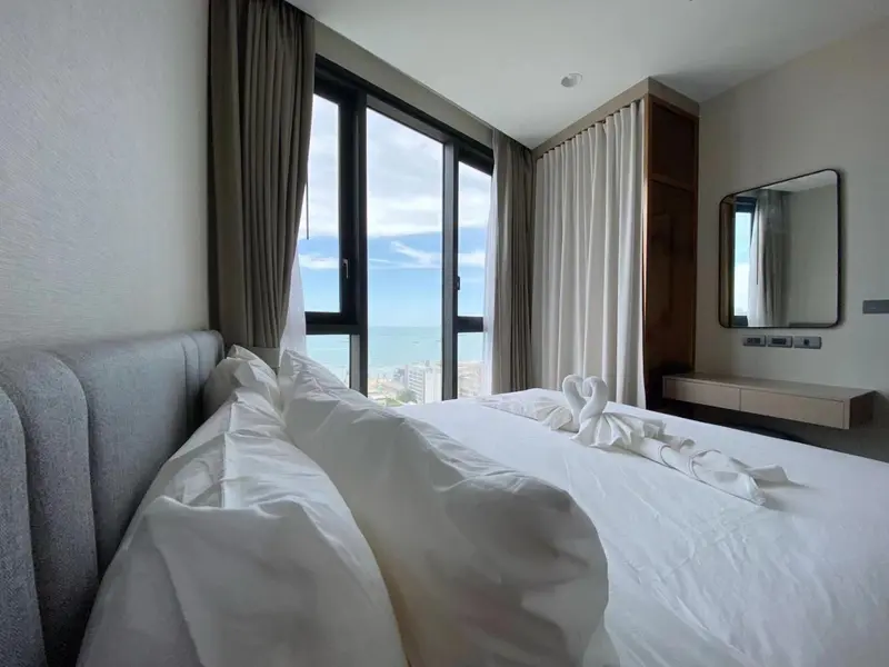 Une chambre lumineuse avec un grand lit et une vue sur la mer.