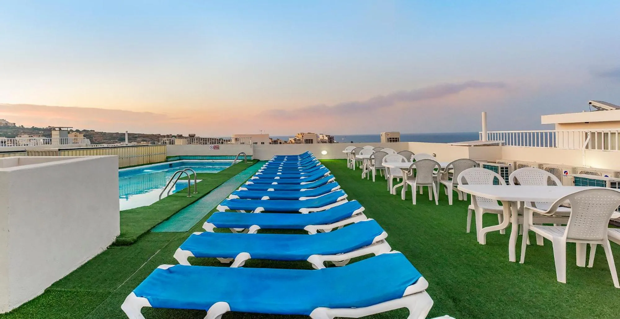 Terrasse avec transats et petite piscine au bord de la mer.