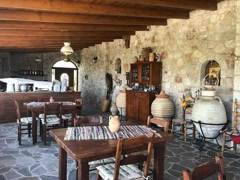 Une salle à manger rustique avec des tables en bois et un bar en fond.