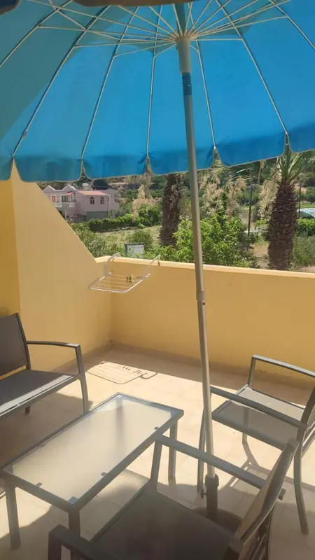 Terrasse avec mobilier de jardin et vue sur la végétation.