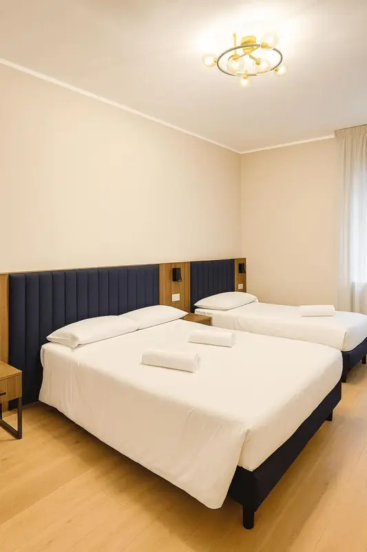 Une chambre avec deux lits simples et une décoration sobre.