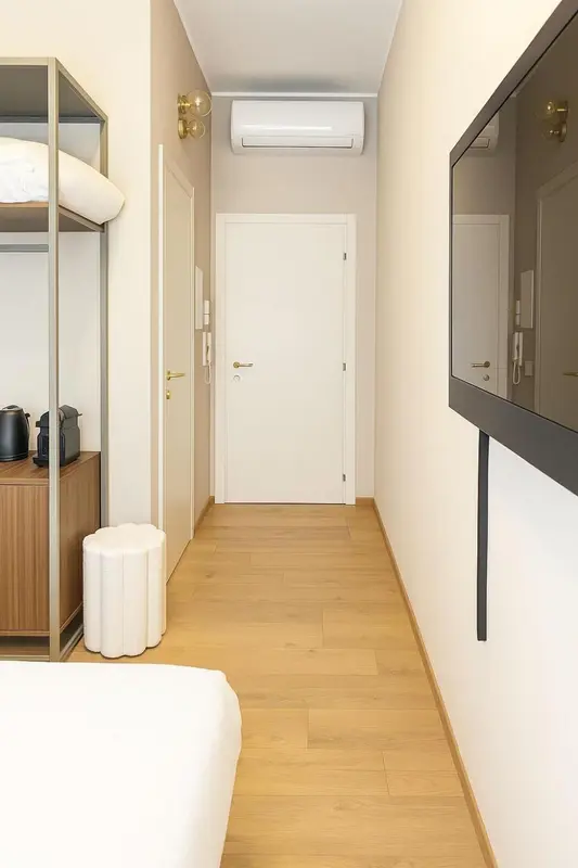 Une chambre lumineuse avec un lit et un téléviseur mural.
