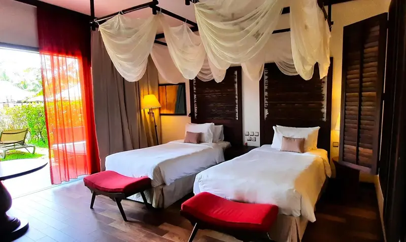 Une chambre lumineuse avec deux lits simples et une décoration soignée.