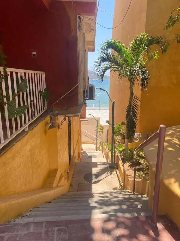 Escalier extérieur menant à une plage ensoleillée.