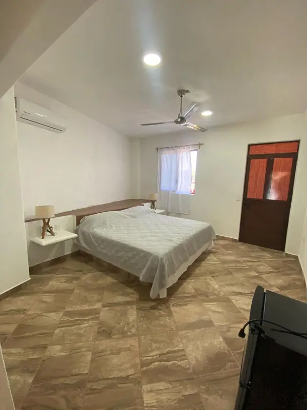 Une chambre lumineuse avec un lit recouvert d'un drap blanc.