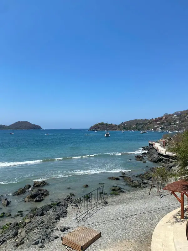 Vue sur une plage rocheuse et une baie ensoleillée.