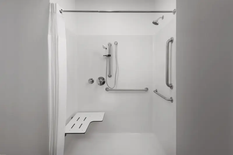 Douche accessible avec barre d'appui et siège rabattable.