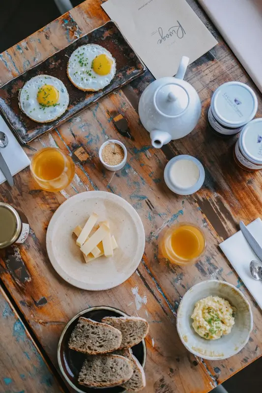 Un petit-déjeuner copieux est présenté sur une table en bois rustique.