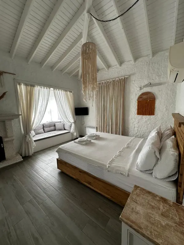 Une chambre lumineuse avec un grand lit et un coin salon.