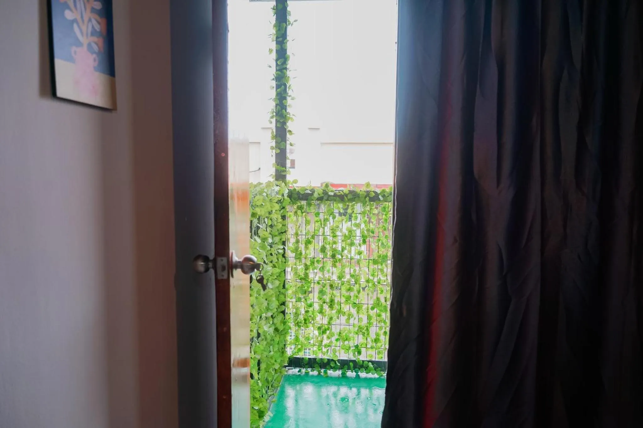 Une porte ouverte donne sur une piscine et une végétation luxuriante.