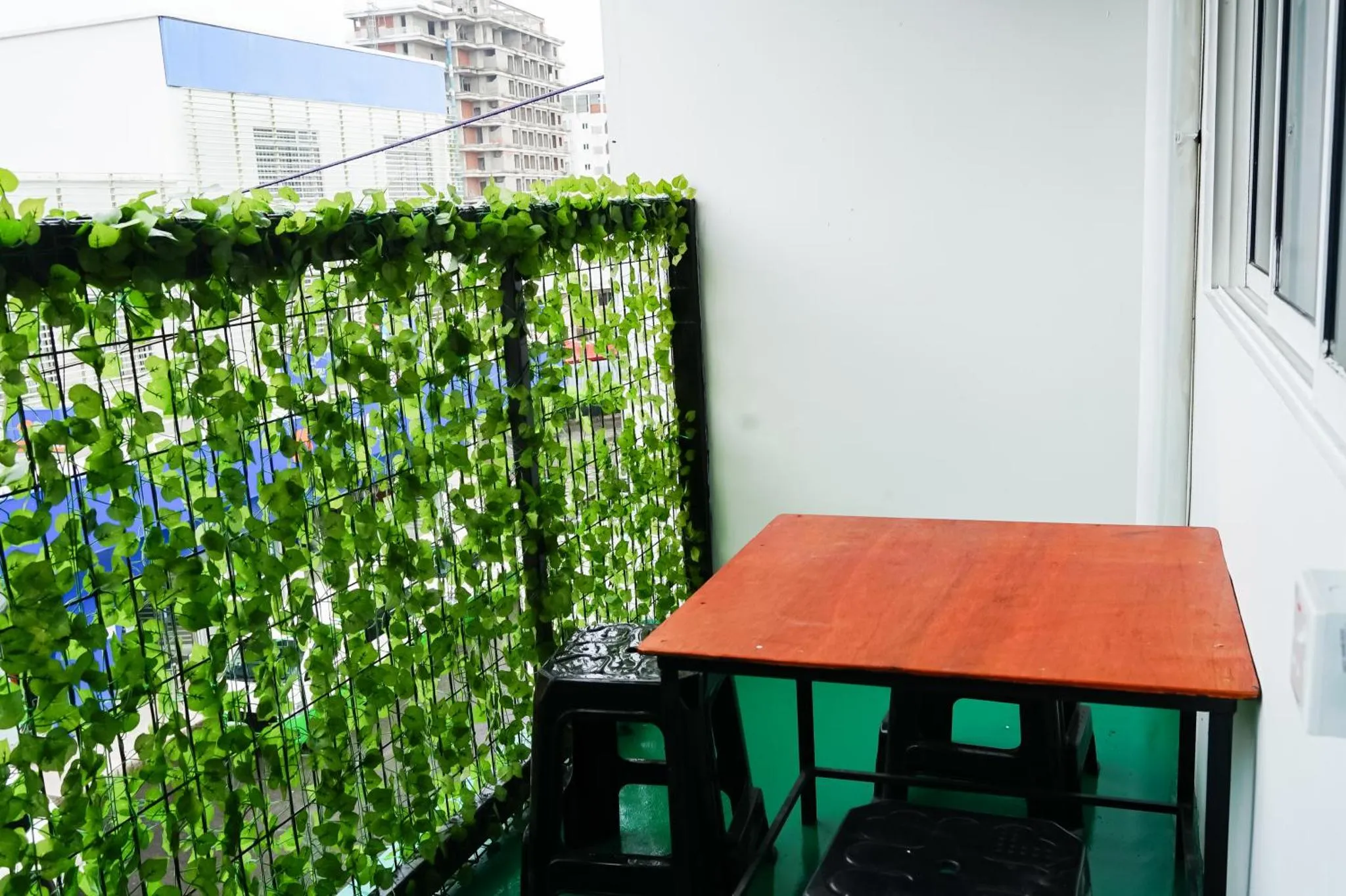 Une terrasse avec une table et des chaises devant une végétation luxuriante.