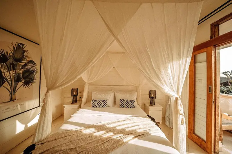 Lit à baldaquin dans une chambre lumineuse et décorée de motifs géométriques.