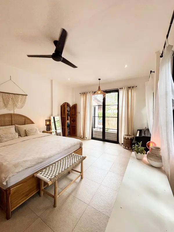 Une chambre lumineuse avec un grand lit et un accès à une terrasse.
