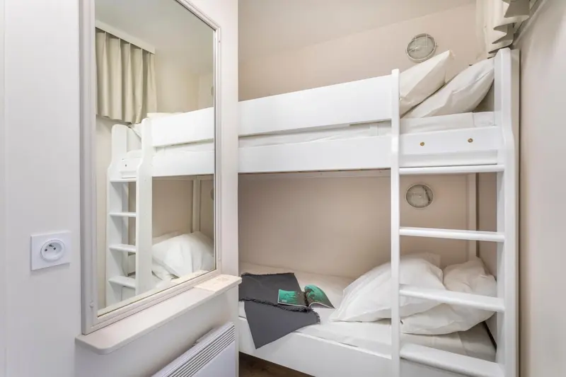 Lit superposé dans une chambre claire et minimaliste.