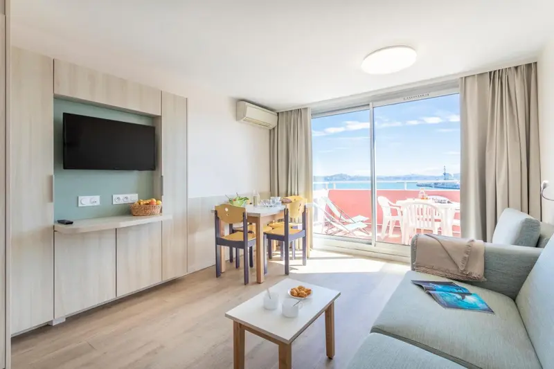 Espace de vie lumineux avec coin repas et accès à une terrasse ensoleillée.