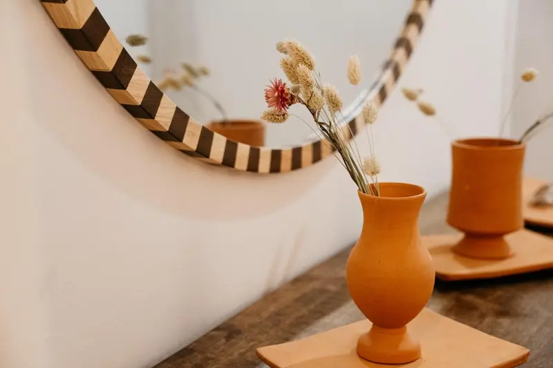 Composition florale dans des vases en céramique sur une console.