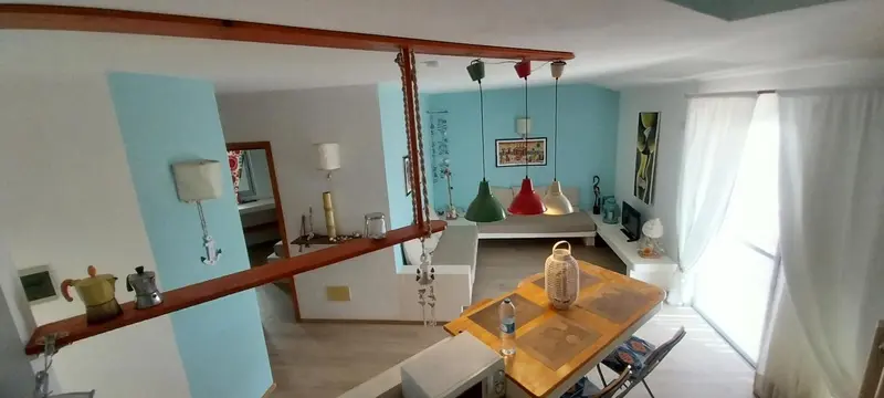 Une salle à manger lumineuse avec une table en bois et des chaises.