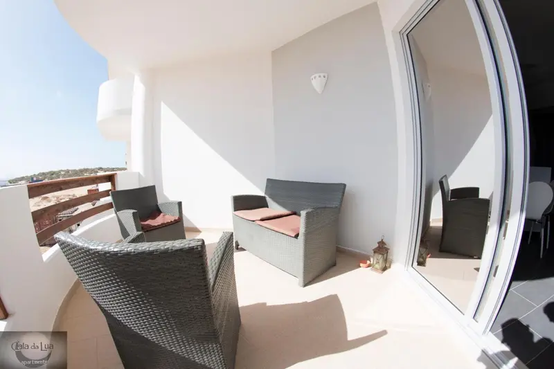Terrasse aménagée avec mobilier d'extérieur et vue sur la mer.