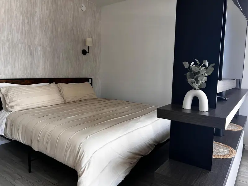 Une chambre lumineuse avec un grand lit et une décoration moderne.