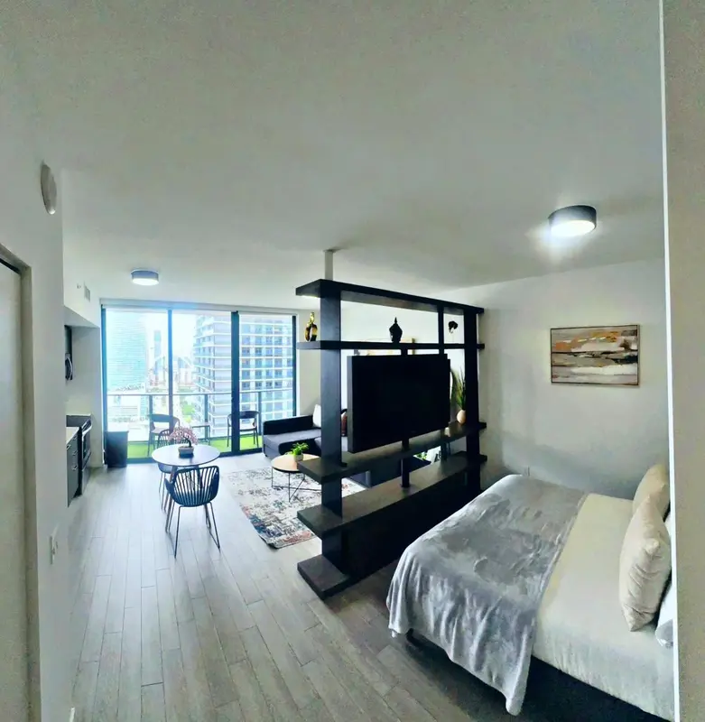 Espace de vie moderne avec un lit, un coin salon et une table basse.