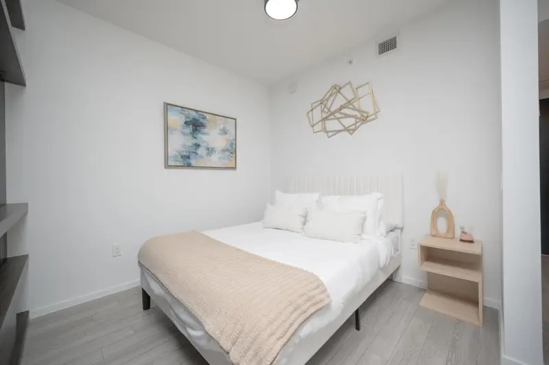 Une chambre lumineuse avec un lit double et une décoration murale.