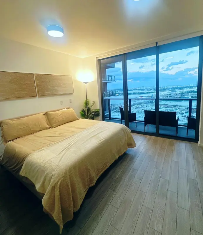 Une chambre lumineuse avec un grand lit et une vue sur la mer.