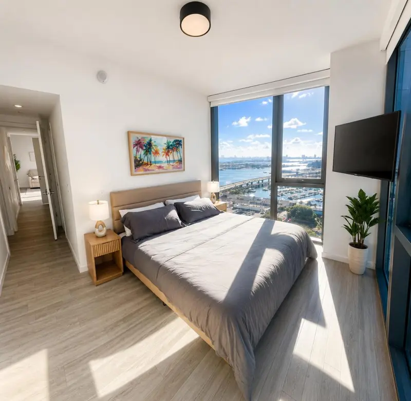 Chambre lumineuse avec un grand lit et une vue sur la mer.