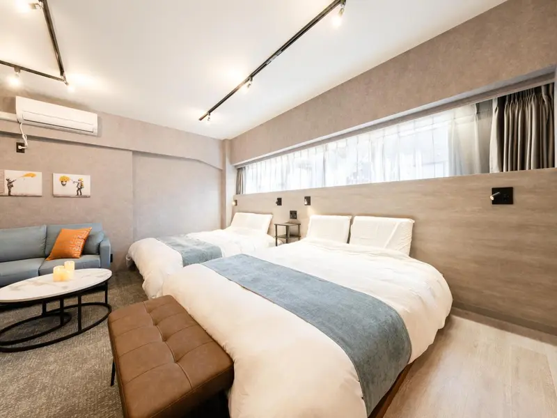 Une chambre lumineuse avec deux lits et un canapé.