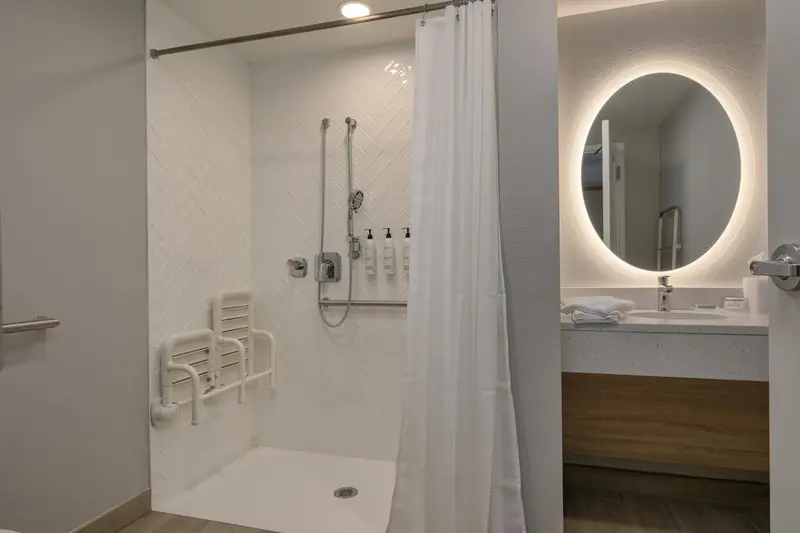 Une douche à l'italienne avec rideau et miroir lumineux.