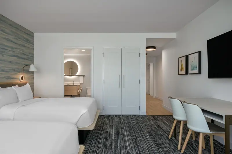 Une chambre lumineuse avec un lit double et un espace repas.