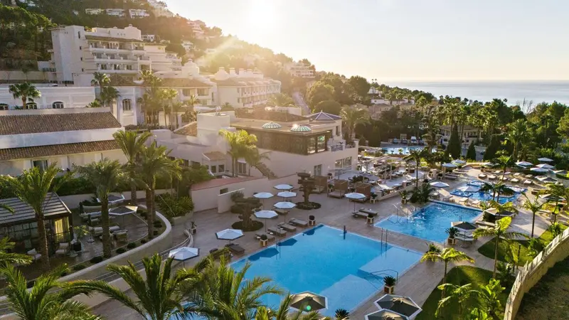 Vue aérienne d'un complexe hôtelier avec piscine et végétation luxuriante.