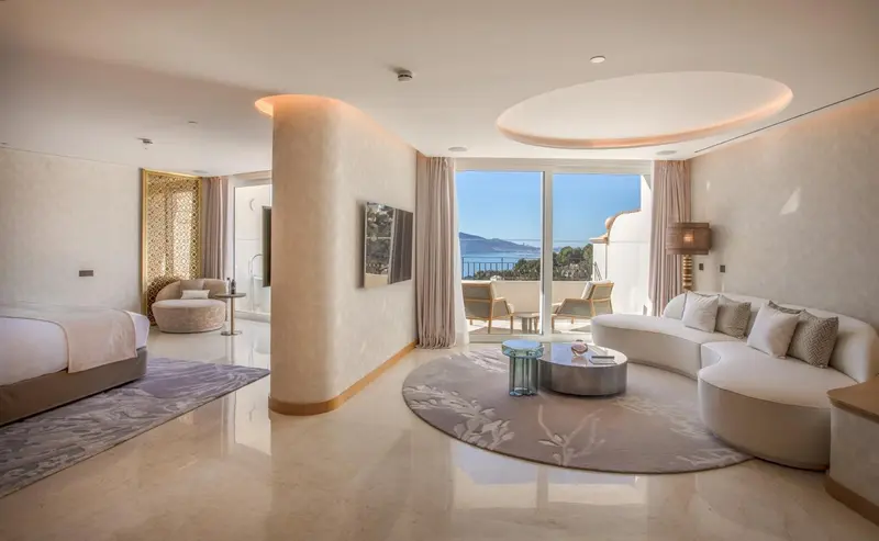 Espace de vie lumineux avec canapé d'angle et vue sur la mer.