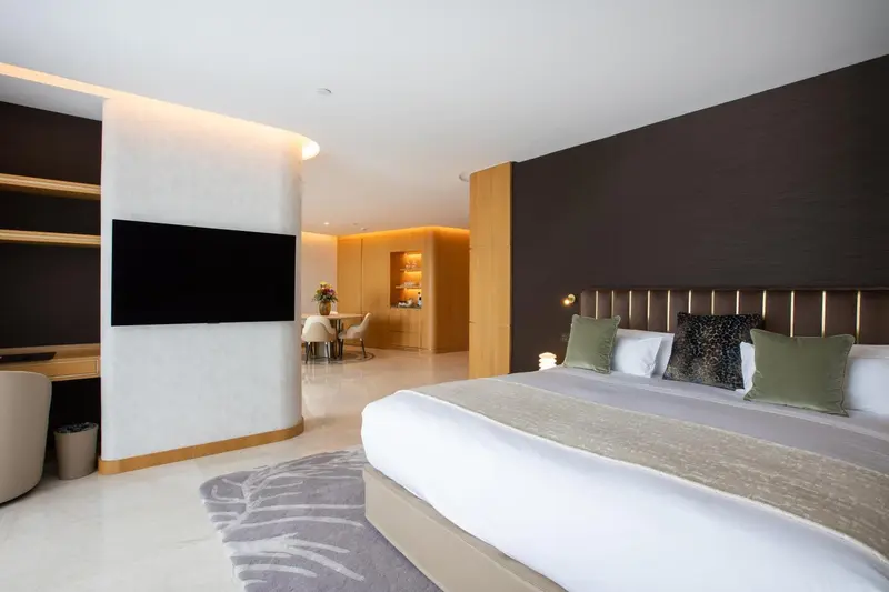 Une chambre lumineuse avec un grand lit et un espace repas.