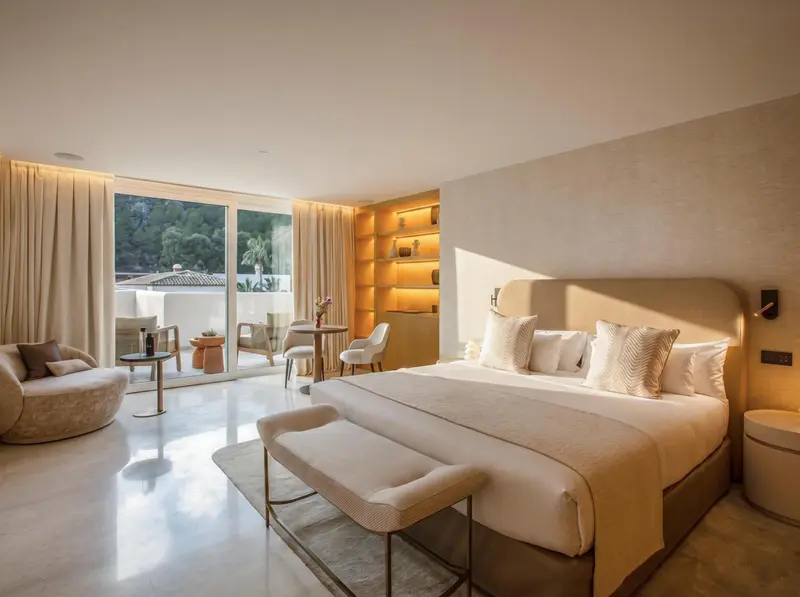 Une chambre lumineuse avec un grand lit et un coin salon.