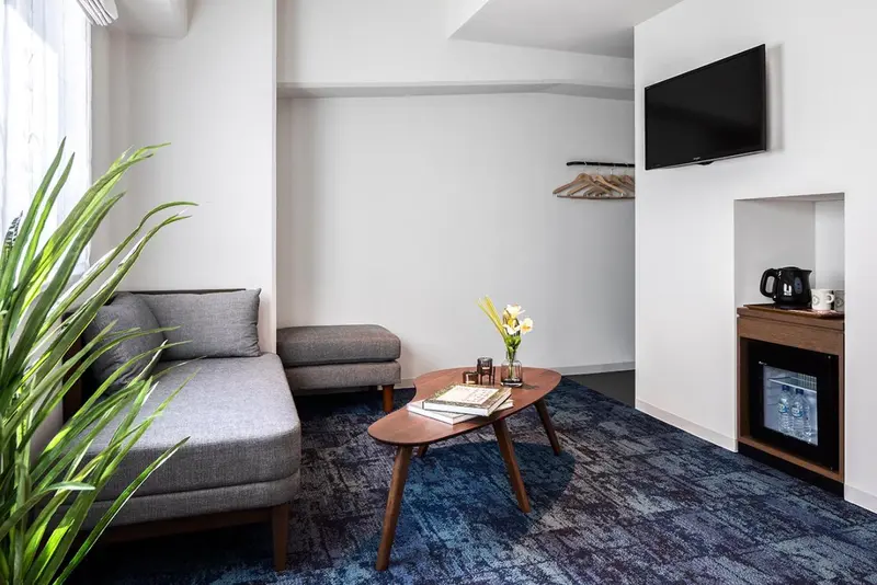 Un espace de séjour lumineux avec un canapé d'angle et une table basse.