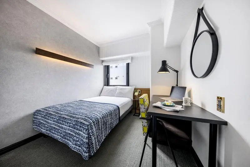Une chambre moderne avec un lit simple et un bureau.