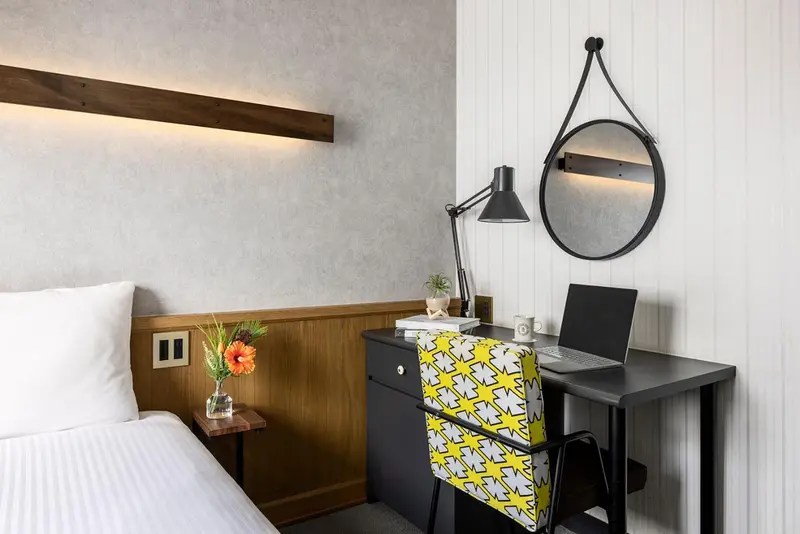 Une chambre d'hôtel lumineuse avec un bureau et un lit.