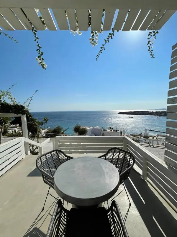 Terrasse avec table et chaises donnant sur la mer.