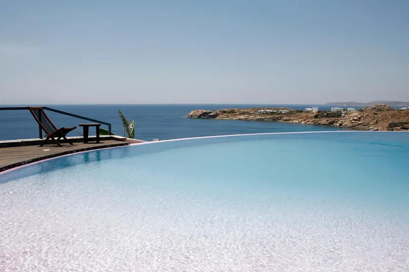 Terrasse avec piscine à débordement donnant sur la mer.