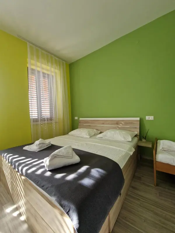 Une chambre lumineuse avec un lit double et des rideaux à rayures.