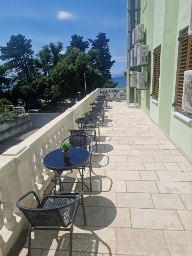 Terrasse avec tables et chaises en bord de mer.