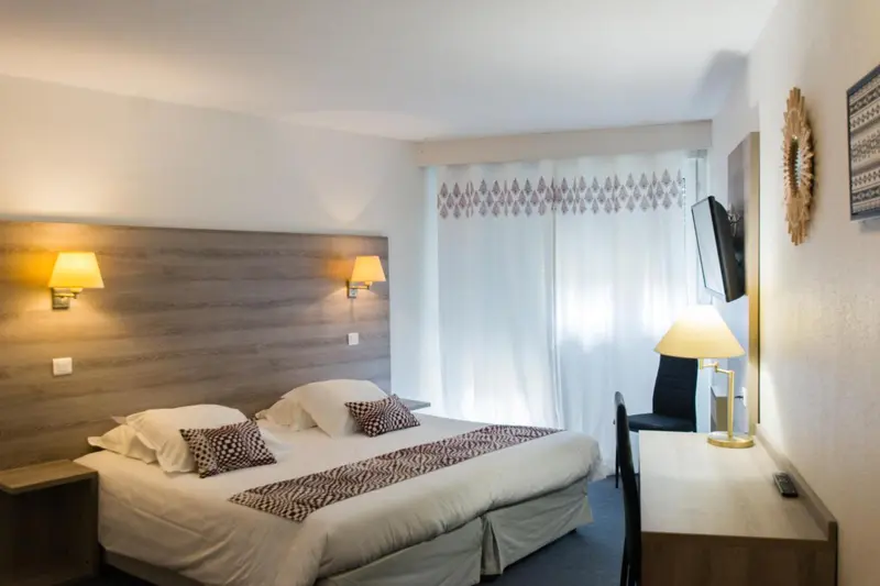 Une chambre d'hôtel avec un lit double et une télévision murale.