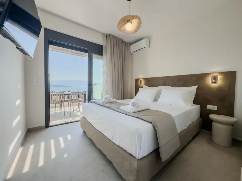 Une chambre lumineuse avec un grand lit et une vue sur la mer.