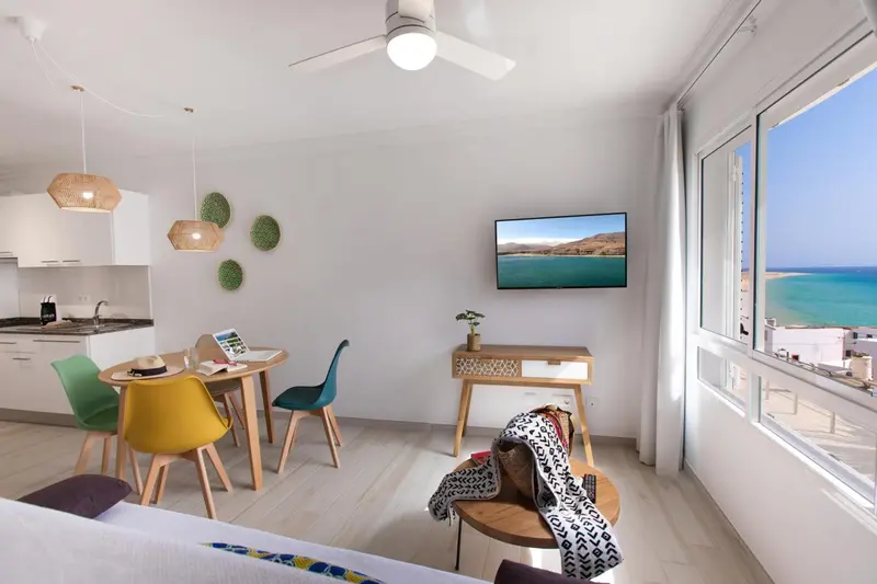 Espace de vie lumineux avec coin repas et vue sur la mer.