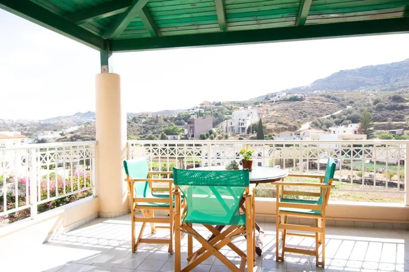 Terrasse avec mobilier de jardin et vue sur un paysage montagneux.